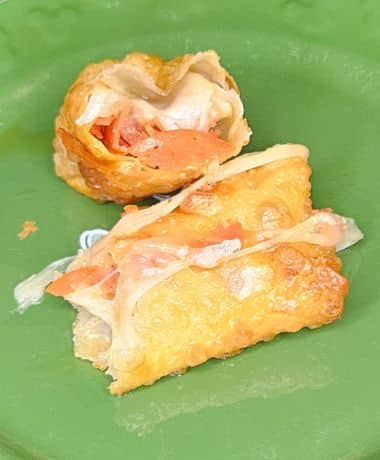Disney Pepperoni Spring Rolls Recipe: one spring roll cut in half showing the pepperoni and mozzarella cheese on the inside.