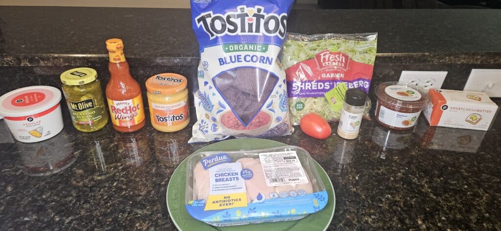 Disney Hades Nachos Recipe Ingredients: sour cream, jalapeno slices, Frank's Red Hot Buffalo Sauce, Tostitos queso, Tostitos blue corn chips, shredded lettuce, roma tomato, garlic powder, salsa, butter, and chicken breasts.